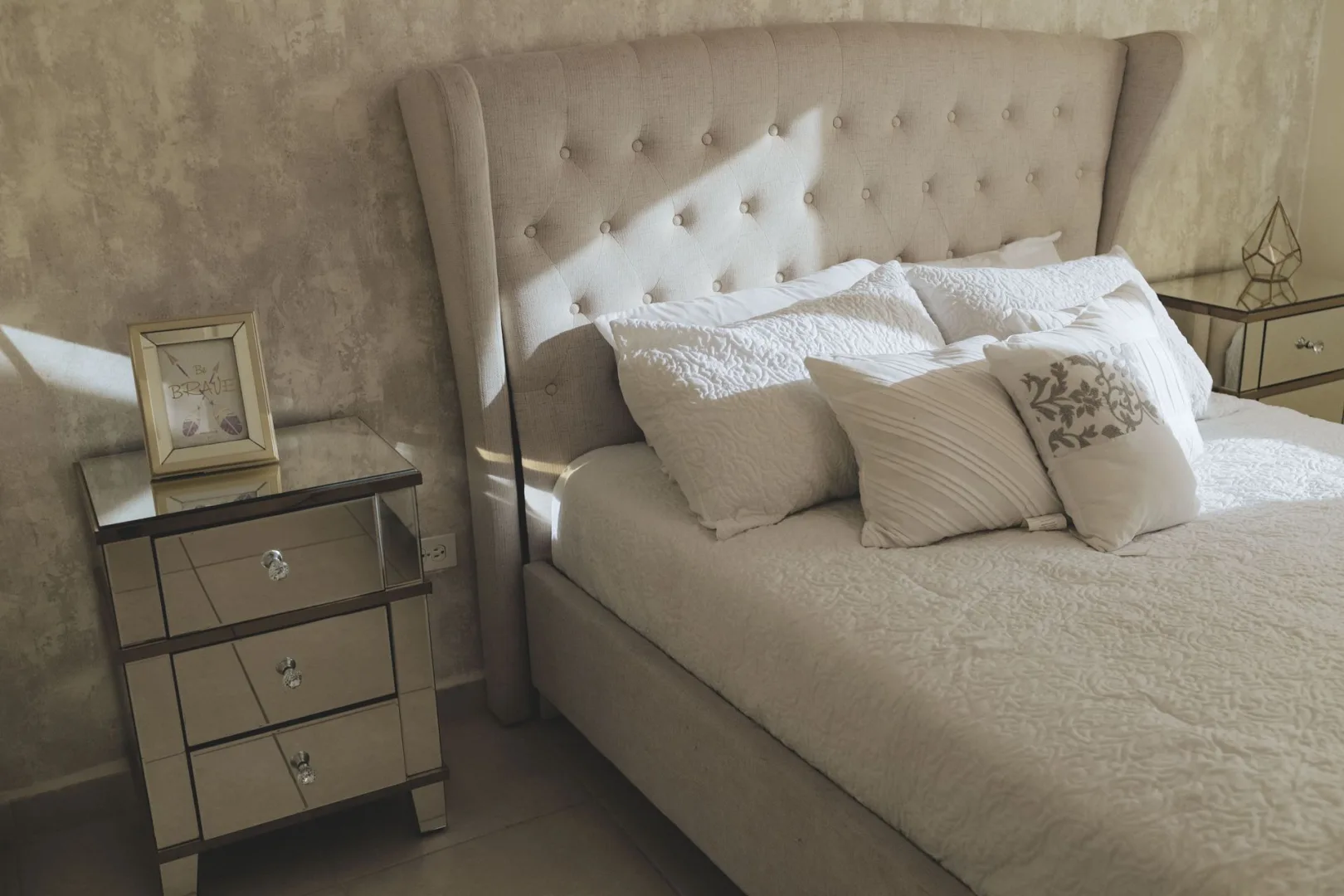 Cama de casal com cabeceira estofada e almofadas