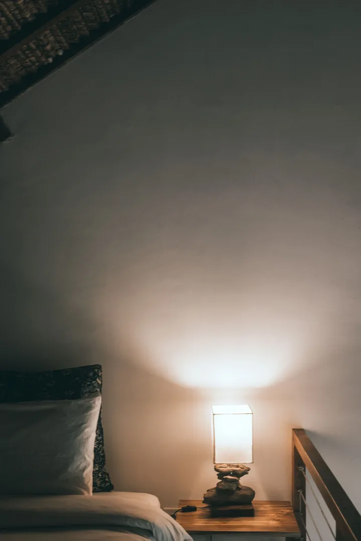 Quarto com abajur de luz quente criando um ambiente aconchegante